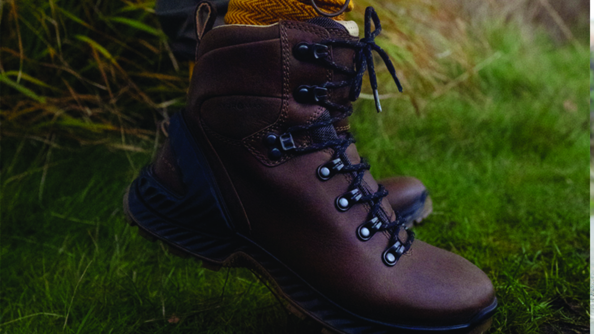 A lifestyle shot of a pair of brown leather hiking boots from ECCO. These boots are perfect for outdoor activities, they are made with premium materials, and known for their comfort, support and durability. The boots feature a durable sole with excellent grip, this can help to reduce the risk of back pain, especially when walking on uneven surfaces. The boots also have a waterproof and breathable lining, that helps to keep the feet dry and comfortable.