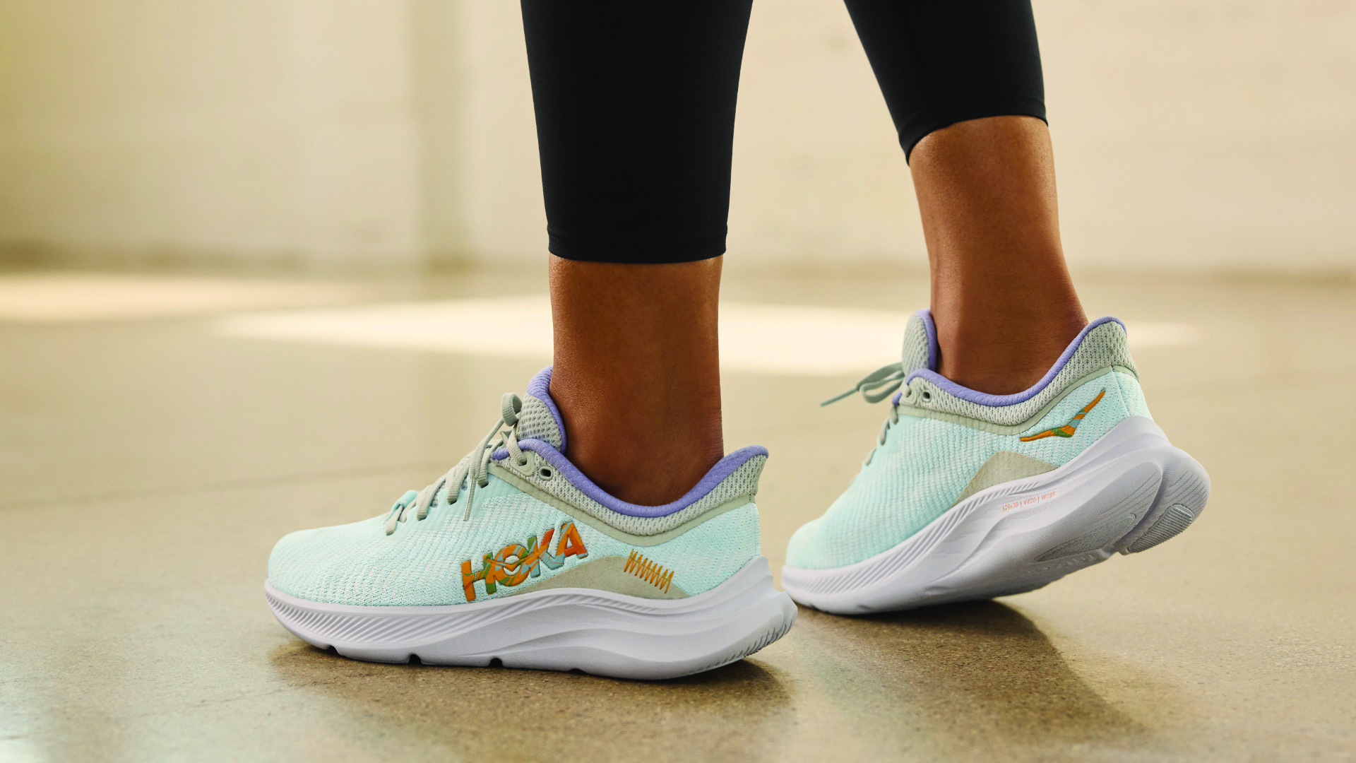 "A close-up of a pair of white HOKA shoes, they are known for their structure and cushioning. The shoes have thick soles and ample cushioning, this can help to reduce the impact of each step and alleviate pressure on the back. These shoes are perfect for runners and people who engage in high-impact activities and looking for a shoe that can help with their back pain.
