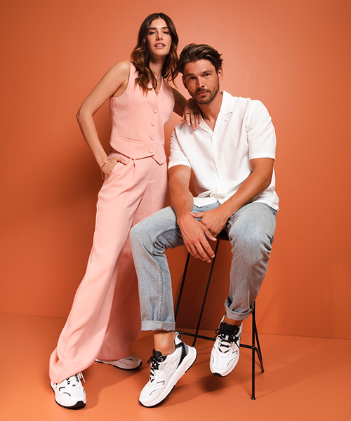 A man and a woman in a studio modelling Xsensible shoes.